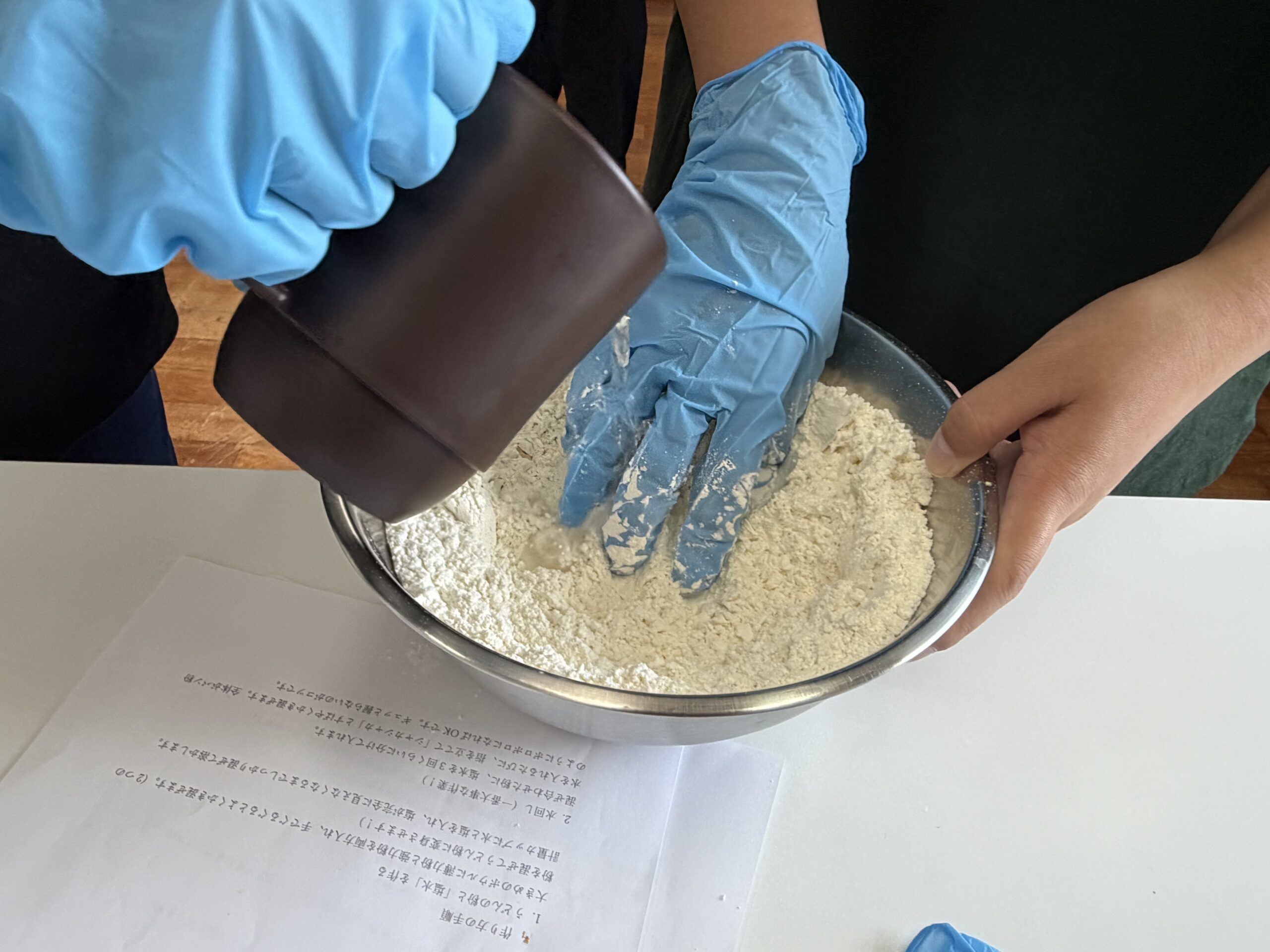 協力してうどんの生地をこねる様子
