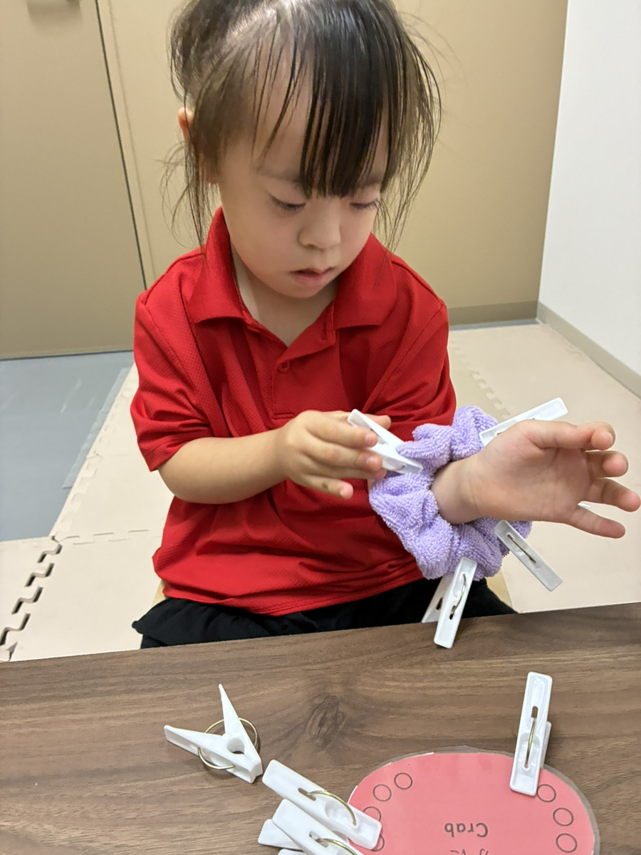 指先で洗濯ばさみをつまんで外す様子