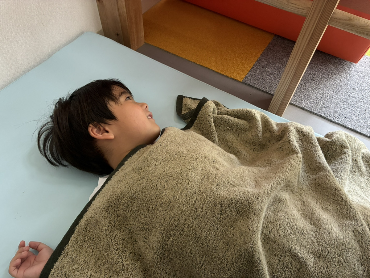 重い布団で気持ちよさそうに眠る子供