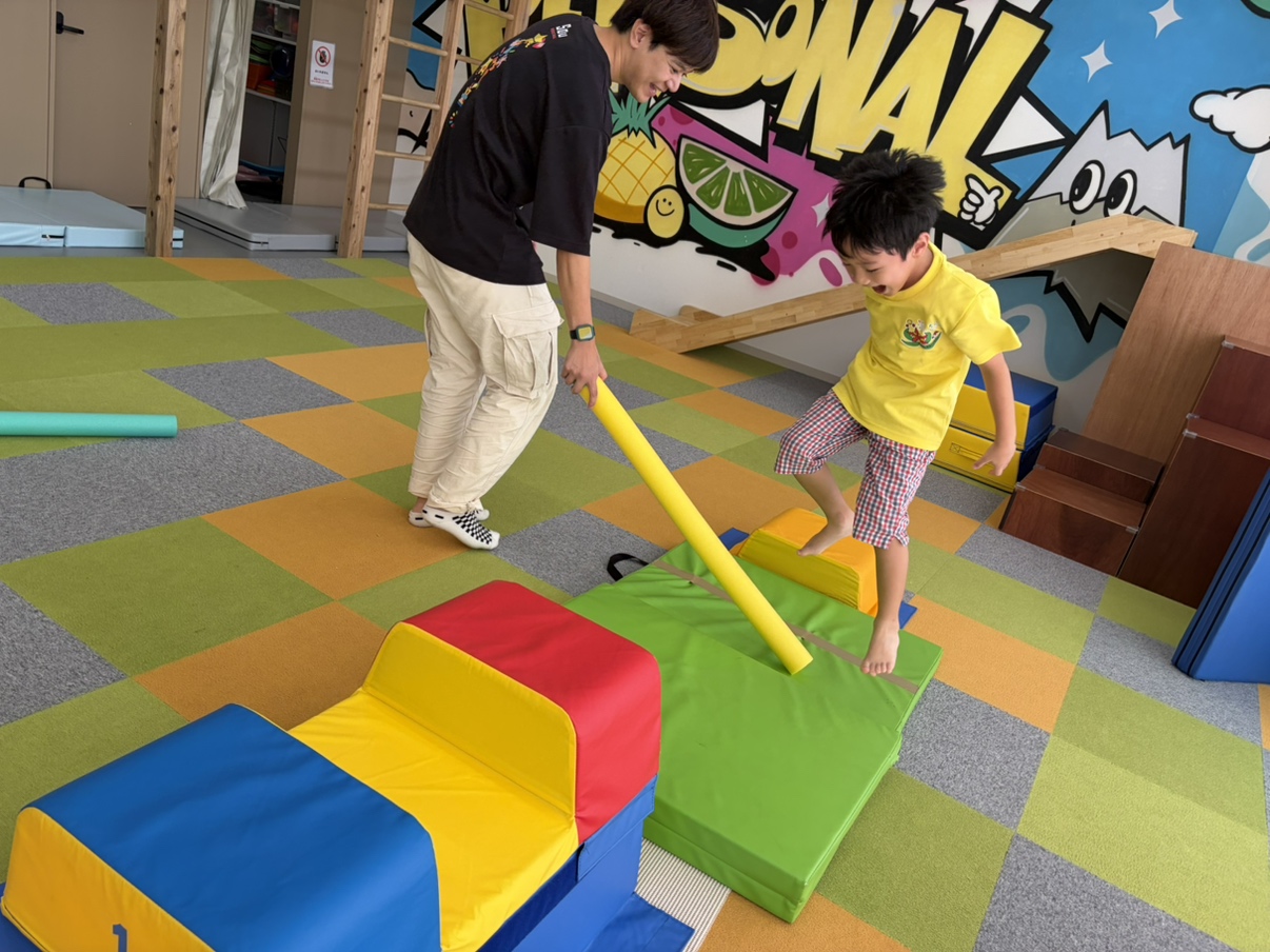飛んでくるスティックをしゃがんでよけるお子さま
